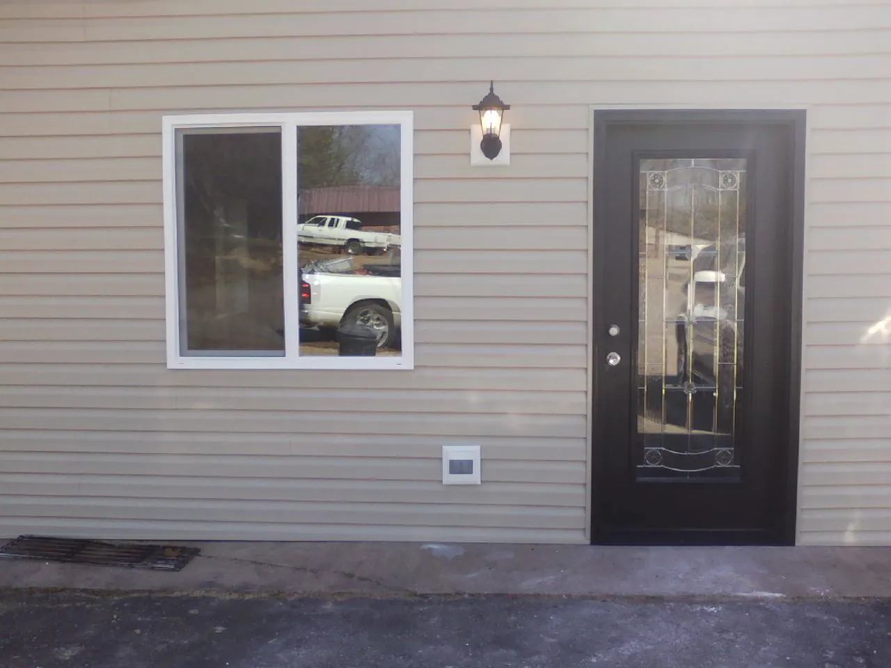 New siding, window and entry door on the side of an addition in Clear Brook